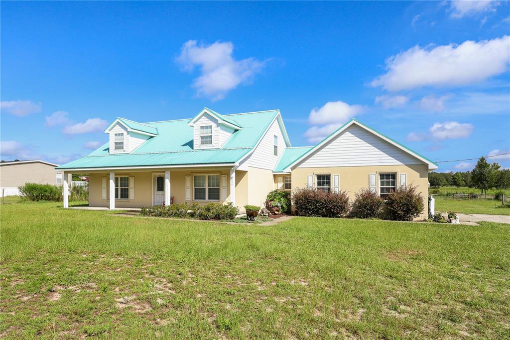 7290 Northeast 106 Terrace Bronson, FL 32621 - Photo 2 of 40 a front view of a house with a yard