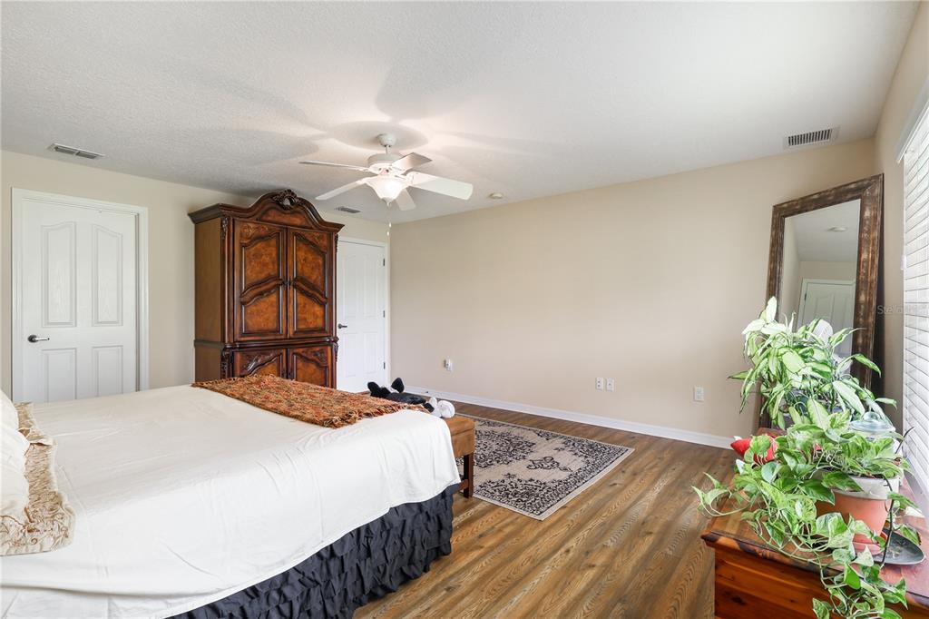 7290 Northeast 106 Terrace Bronson, FL 32621 - Photo 30 of 40 a bedroom with a bed and a potted plant