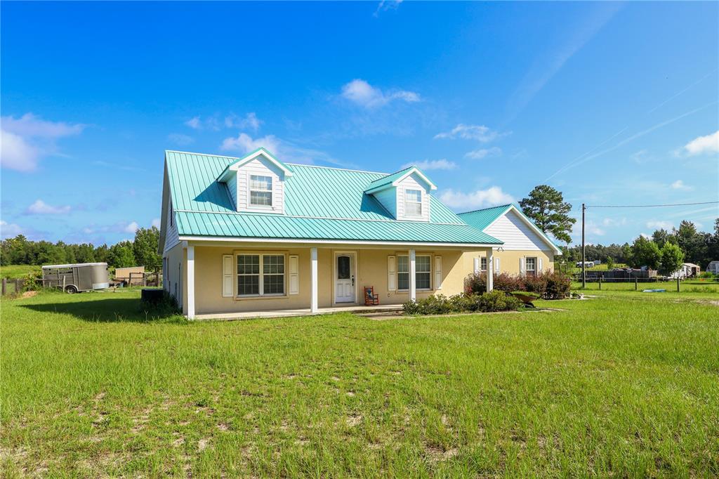 7290 Northeast 106 Terrace Bronson, FL 32621 - Photo 3 of 40 a front view of a house with a yard