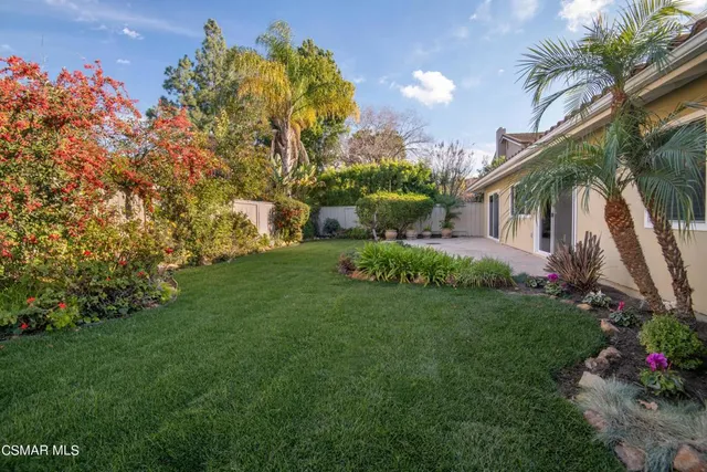 a view of backyard with swimming pool and green space