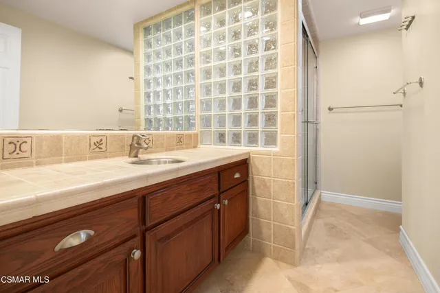 a bathroom with a sink a vanity and a shower