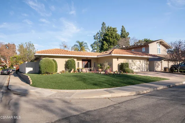 a view of a big house with a big yard and potted plants