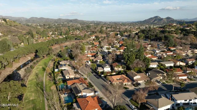 an aerial view of residential houses with outdoor space and trees
