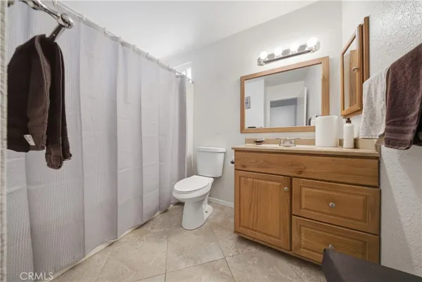 a bathroom with a granite countertop sink a mirror and a toilet