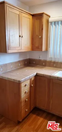 a kitchen with a sink cabinets and a wooden floor