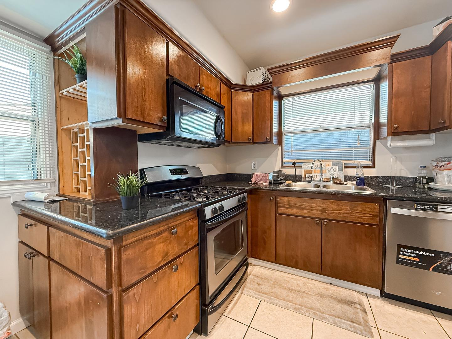 558 A Street Hayward, CA 94541 - Photo 10 of 37 a kitchen with stainless steel appliances granite countertop a stove a sink and a microwave