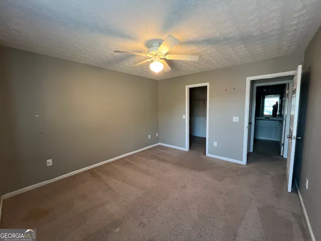 an empty room with closet and a chandelier fan