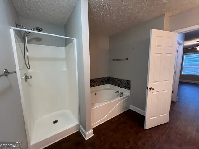 a bathroom with a tub shower and sink