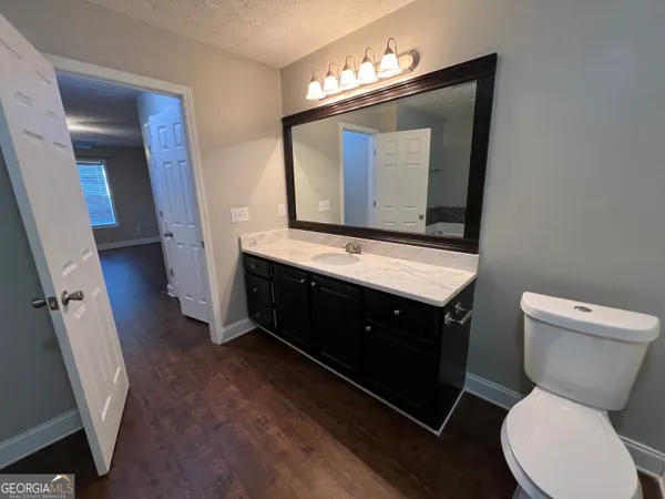 a bathroom with a toilet sink and mirror