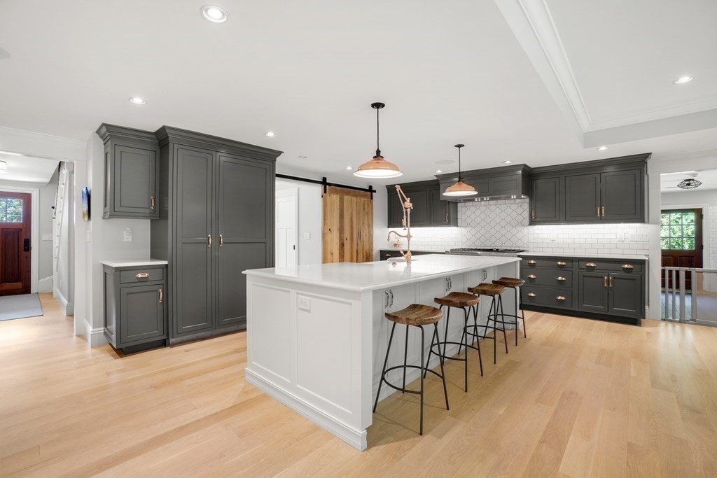 12 Swarthmore Road Wellesley, MA 02482 - Photo 4 of 38 a kitchen with stainless steel appliances kitchen island granite countertop a table chairs and a refrigerator