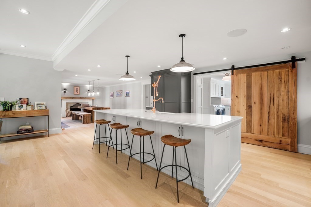 12 Swarthmore Road Wellesley, MA 02482 - Photo 7 of 38 a kitchen with stainless steel appliances kitchen island granite countertop a table chairs in it and wooden floors