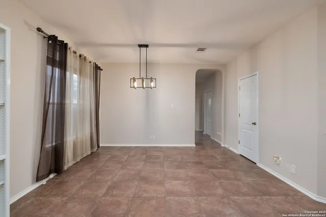 a kitchen with stainless steel appliances granite countertop a table chairs sink and refrigerator