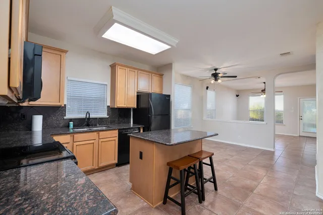 a kitchen with stainless steel appliances granite countertop white cabinets granite counter tops and a window