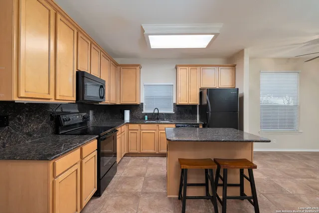 a kitchen with stainless steel appliances granite countertop a refrigerator and a stove top oven