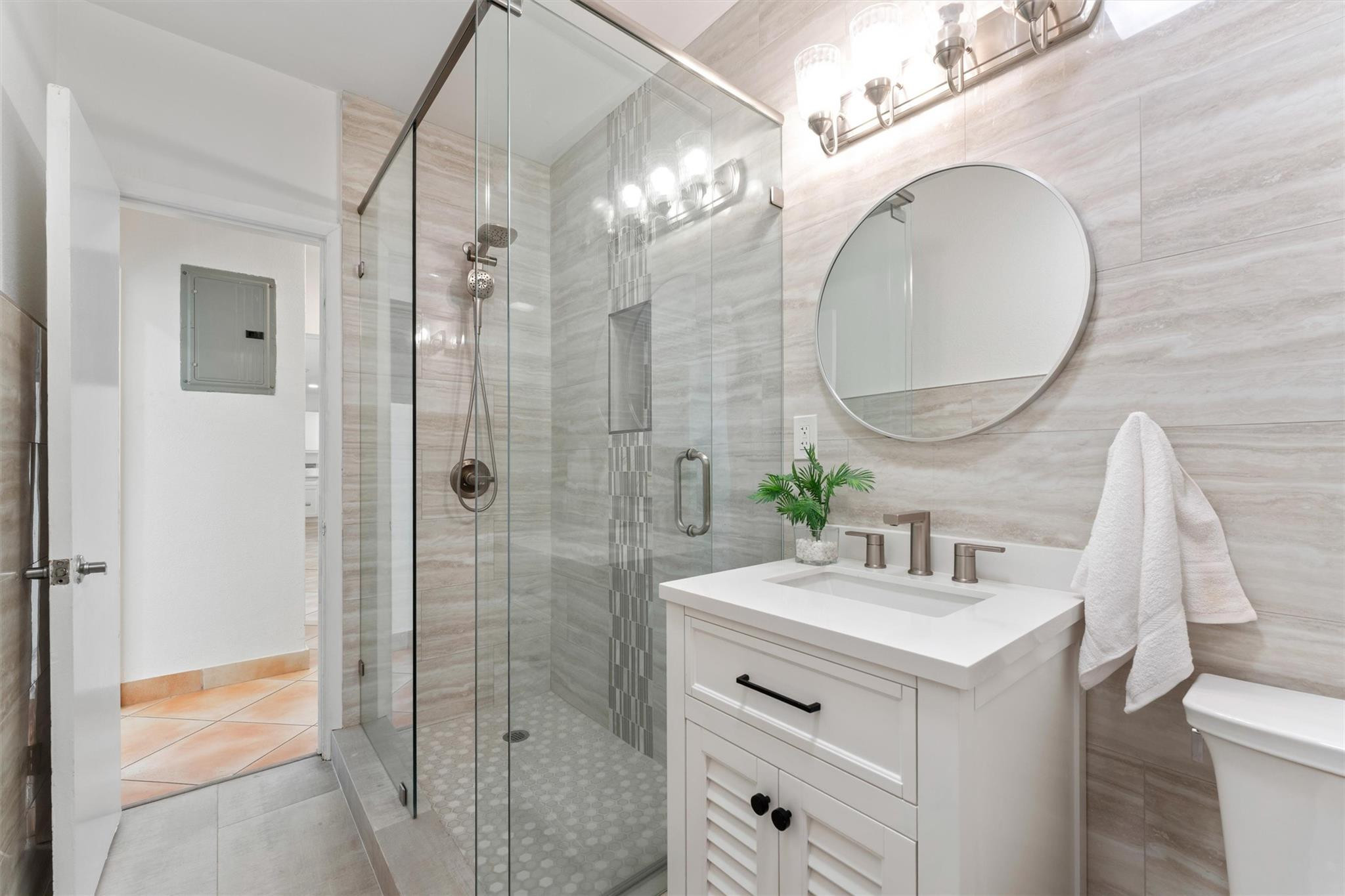 3203 Dover Road Pompano Beach, FL 33062 - Photo 22 of 45 a bathroom with a sink a mirror a vanity and shower