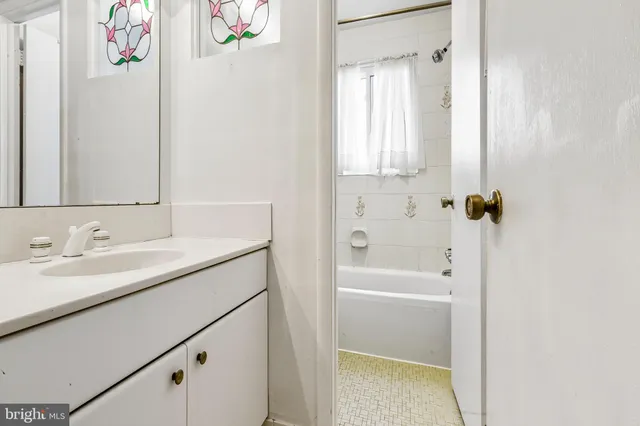 a bathroom with a granite countertop sink a mirror a vanity and a shower