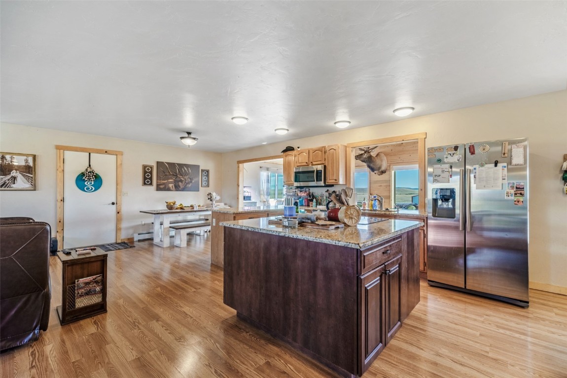 465 Litmer Road Jefferson, CO 80456 - Photo 20 of 50 Kitchen with stainless steel appliances, light wood finished floors, light stone counters, and dark brown cabinets
