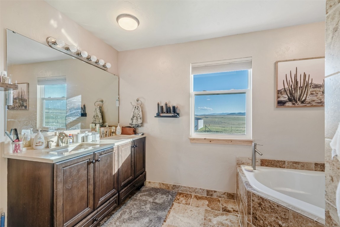 465 Litmer Road Jefferson, CO 80456 - Photo 33 of 50 Full bath with double vanity, a bath, and stone tile flooring