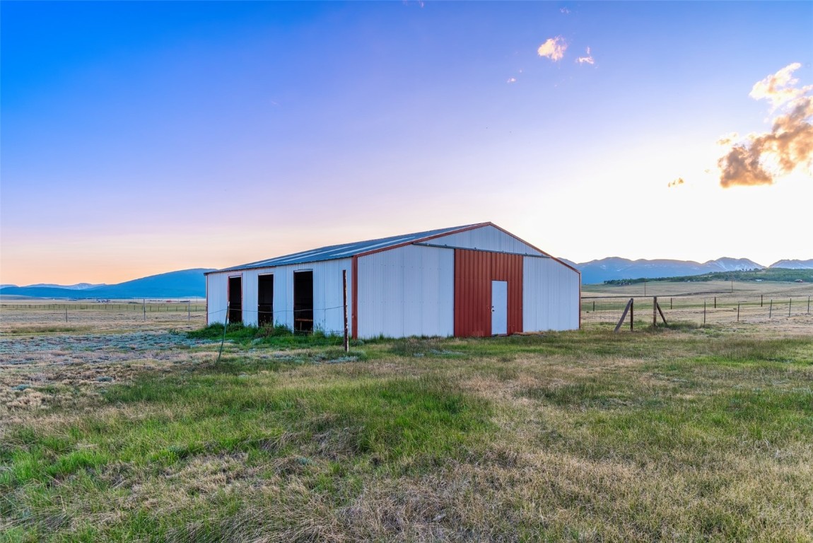 465 Litmer Road Jefferson, CO 80456 - Photo 5 of 50 Outdoor structure at dusk with a pole building, a mountain view, and a view of rural / pastoral area