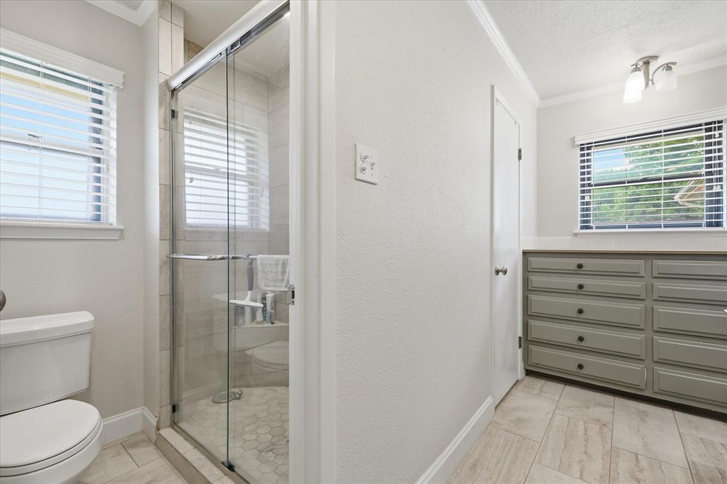 7200 Tamarack Road Benbrook, TX 76116 - Photo 22 of 38 Walk-in shower enclosure with clear glass doors and hexagonal tile flooring.