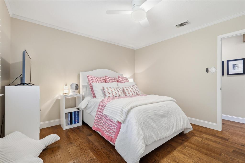 7200 Tamarack Road Benbrook, TX 76116 - Photo 26 of 38 Bedroom #3 featuring wood-finish flooring, a white ceiling fan, and crown molding.