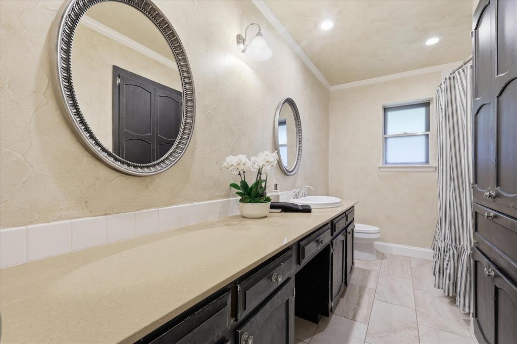 7200 Tamarack Road Benbrook, TX 76116 - Photo 27 of 38 Bathroom vanity with undermount sink, built-in cabinetry,and framed mirrors.