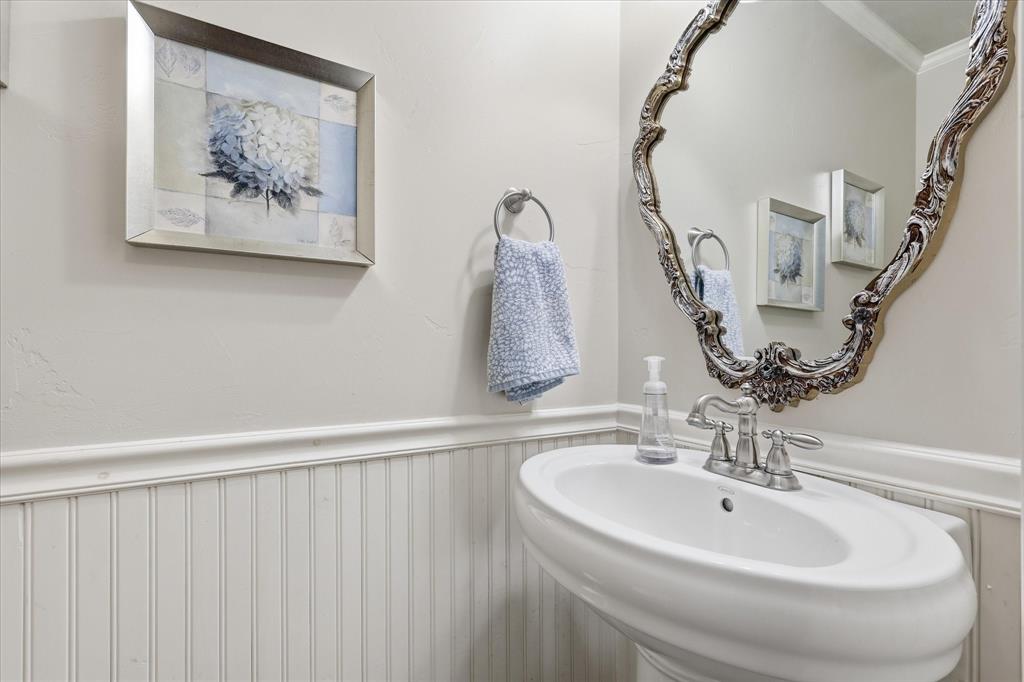7200 Tamarack Road Benbrook, TX 76116 - Photo 28 of 38 Half bath off laundry room with pedestal sink, beadboard and wainscoting.
