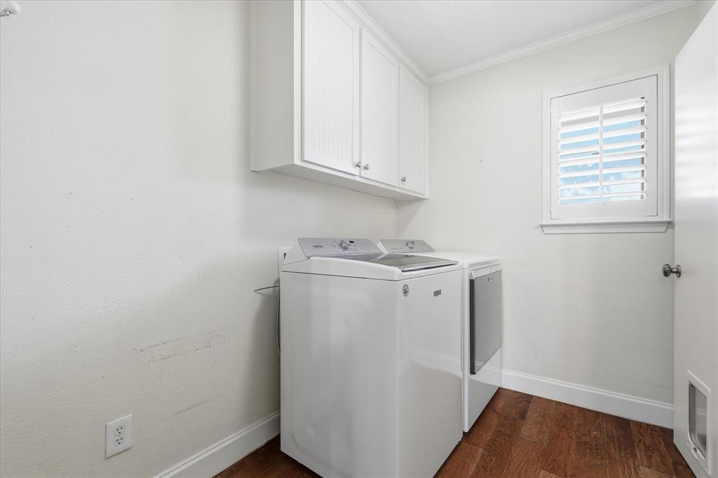 7200 Tamarack Road Benbrook, TX 76116 - Photo 29 of 38 Functional laundry room featuring wood-finish flooring, white built-in cabinetry, and a window with white plantation shutters.