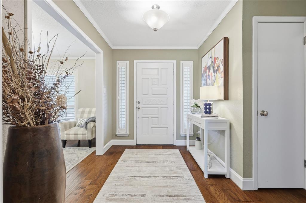 7200 Tamarack Road Benbrook, TX 76116 - Photo 5 of 38 Entryway featuring wood-finish flooring, a paneled front door with sidelight windows, and crown molding.