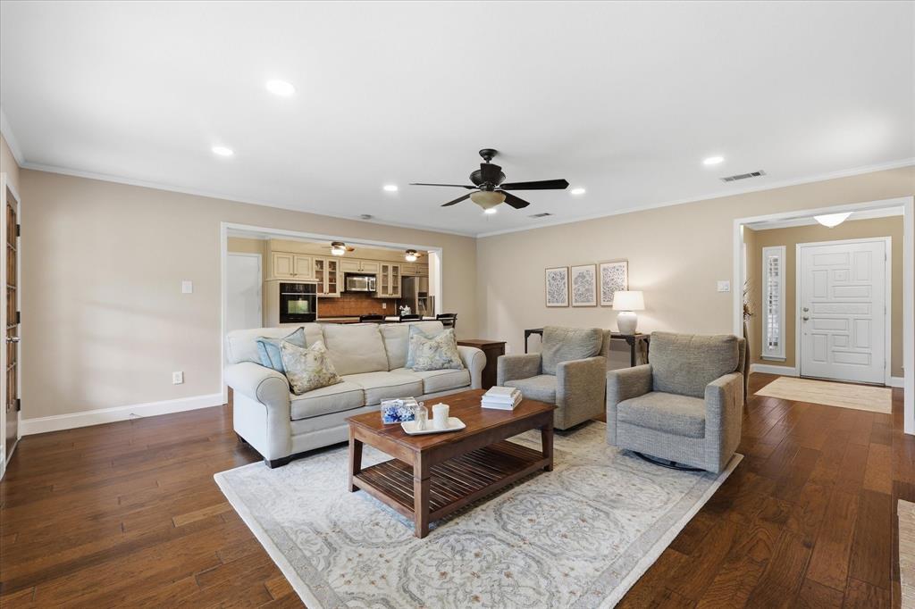 7200 Tamarack Road Benbrook, TX 76116 - Photo 8 of 38 Spacious living room featuring wood-finish flooring throughout the home. Connected to galley eat-in kitchen.