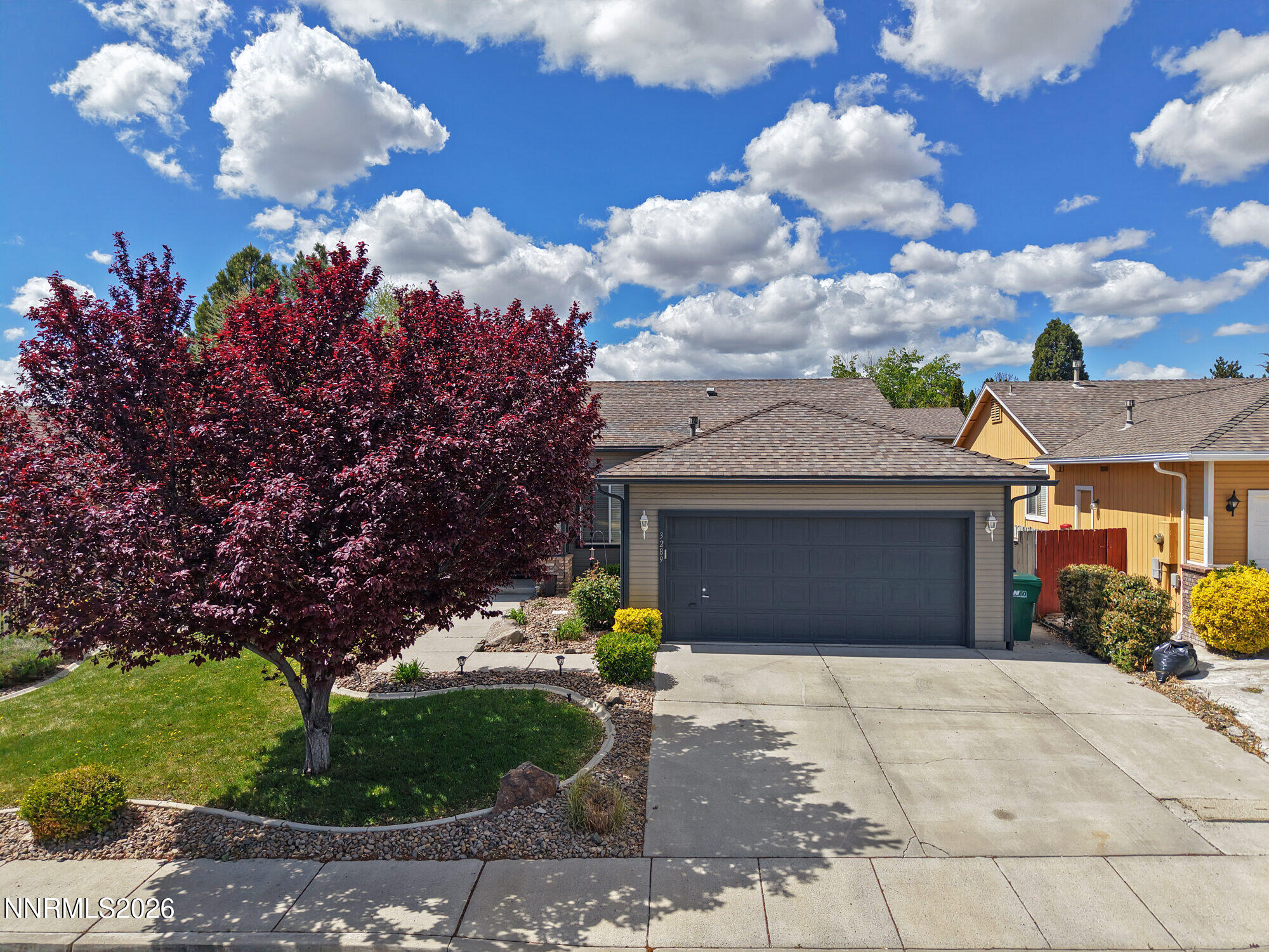 3289 Epic Avenue Reno, NV 89512 - Photo 3 of 32 a front view of a house with a yard and a garage