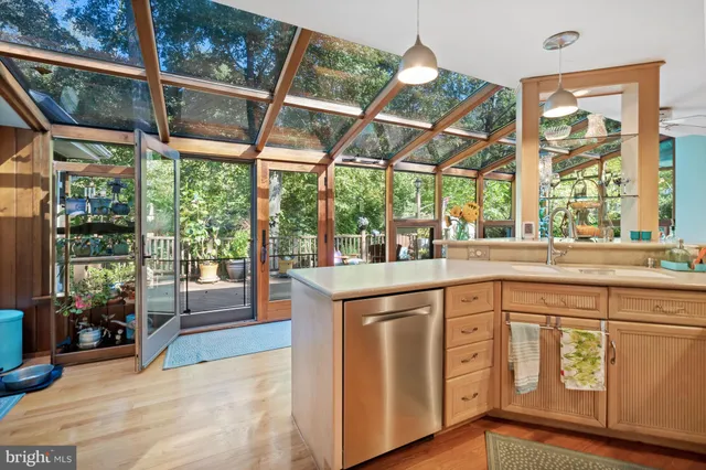 a kitchen with white cabinets and a large window