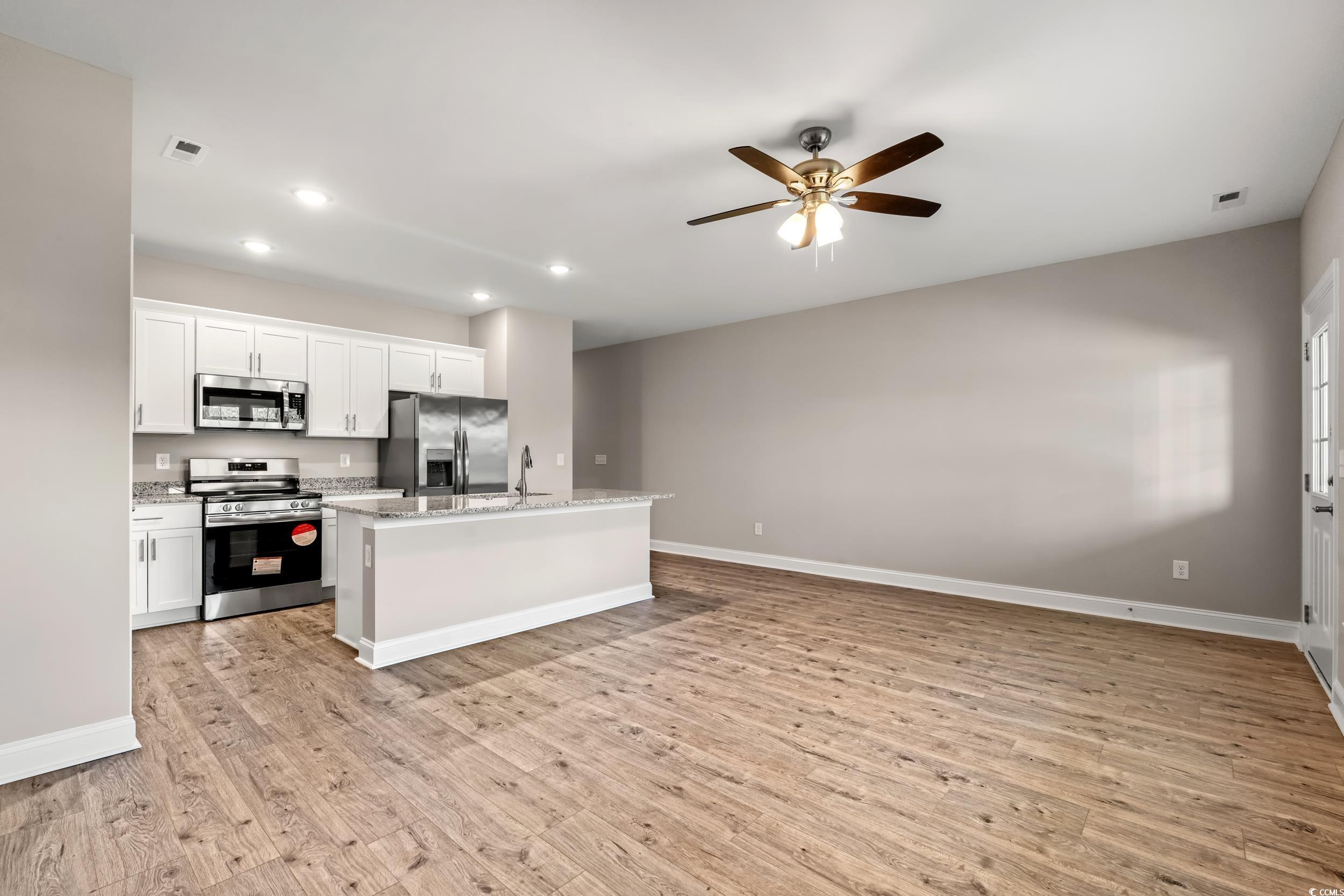 344 Kiskadee Loop, Unit B Conway, SC 29526 - Photo 4 of 32 Kitchen with white cabinetry, ceiling fan, an isla
