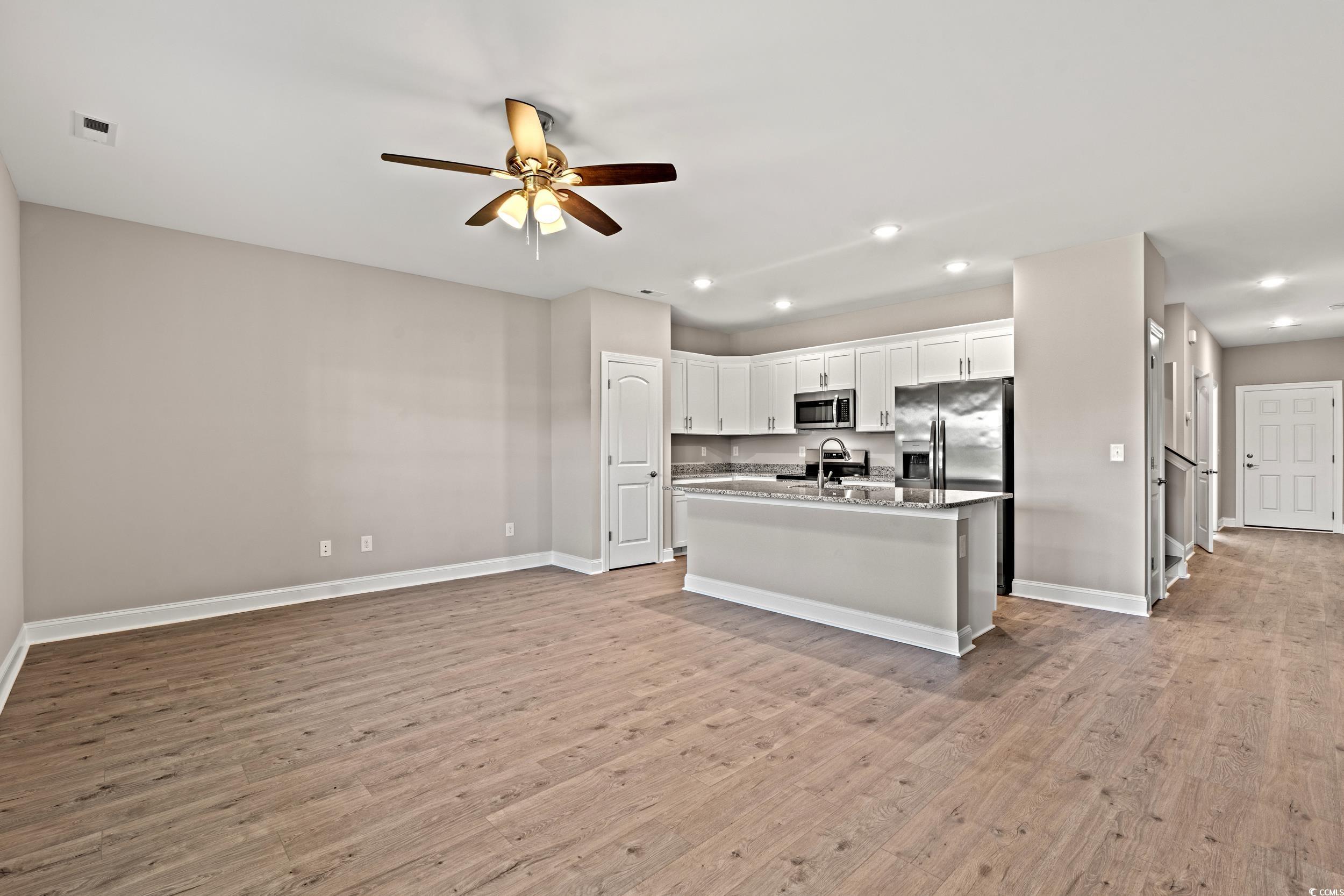 344 Kiskadee Loop, Unit B Conway, SC 29526 - Photo 5 of 32 Kitchen featuring white cabinetry, light hardwood