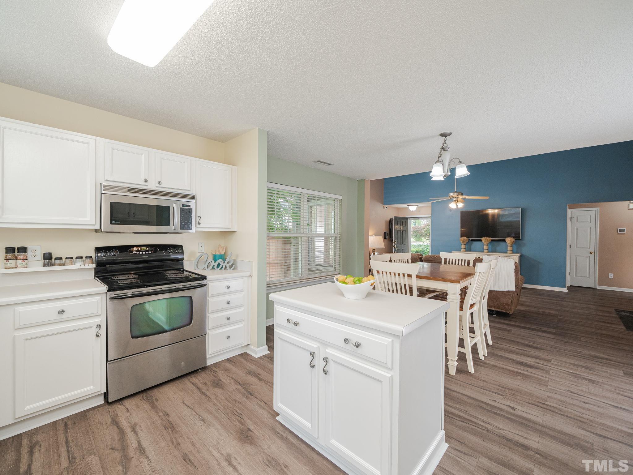 4117 Hopper Street Raleigh, NC 27616 - Photo 8 of 30 a kitchen with a stove a sink and a refrigerator