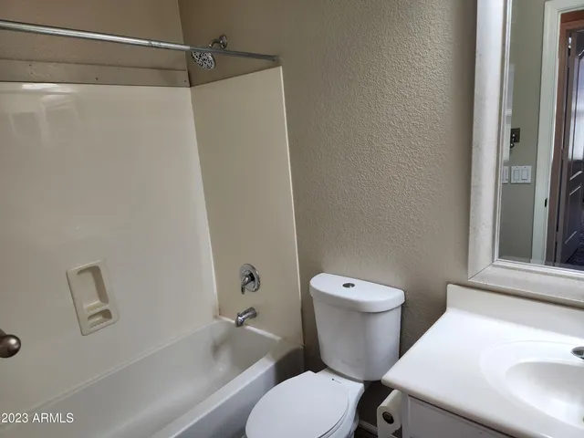 a white toilet sitting next to a bath tub