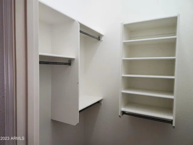 a view of walk in closet with empty racks