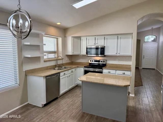 a kitchen with stainless steel appliances granite countertop a stove a sink and a microwave
