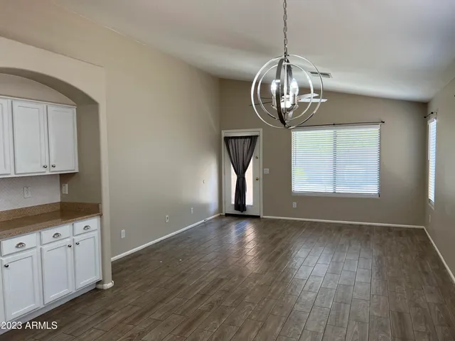 a view of empty room with wooden floor and window