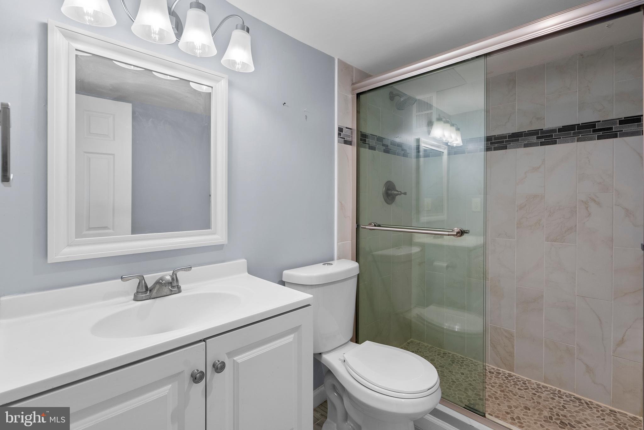 1420 N Street Northwest, Unit 914 Washington, DC 20005 - Photo 16 of 23 a bathroom with a shower sink vanity mirror and toilet