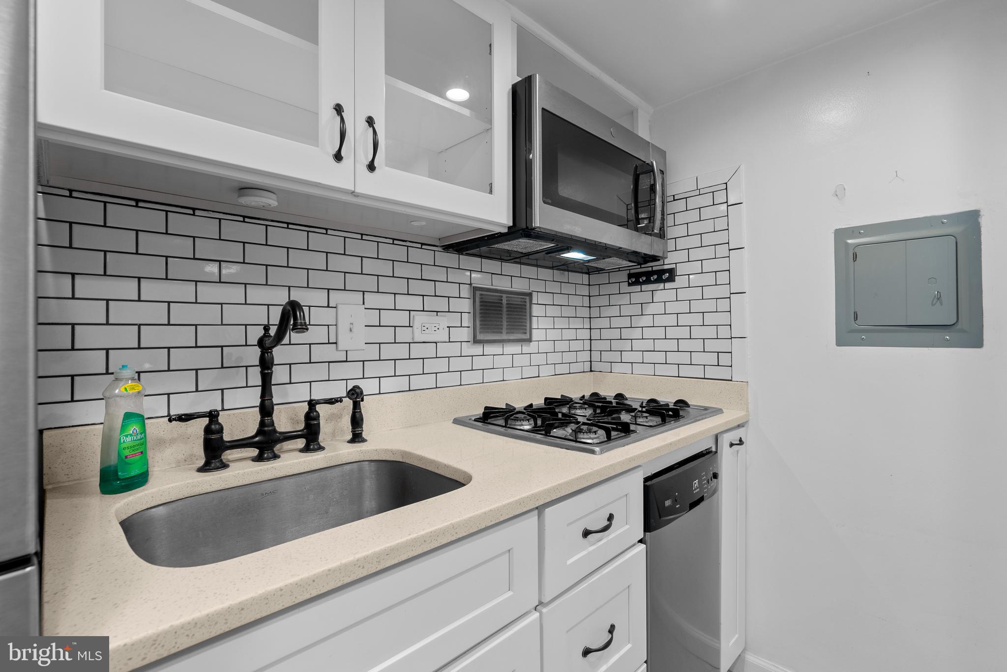 1420 N Street Northwest, Unit 914 Washington, DC 20005 - Photo 7 of 23 a kitchen with stainless steel appliances a sink a stove and cabinets