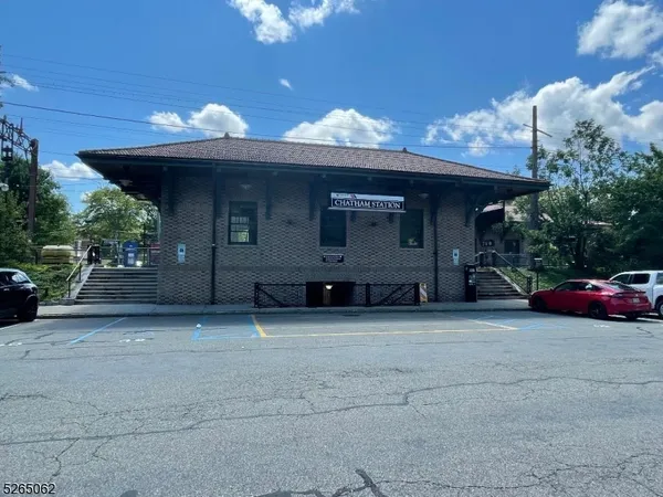 a view of a house with a garage and a car parked under a yard