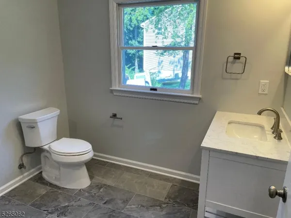 a bathroom with a sink toilet and window