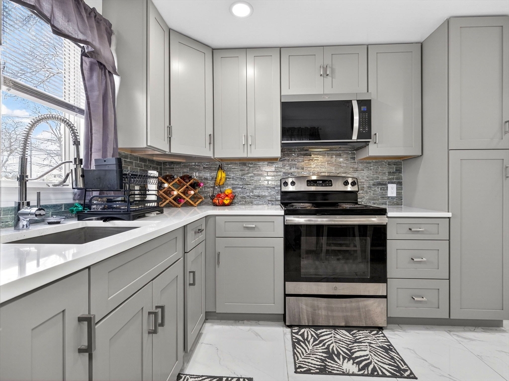 19 Melba Way Boston, MA 02136 - Photo 11 of 34 a kitchen with stainless steel appliances a stove a sink and a microwave