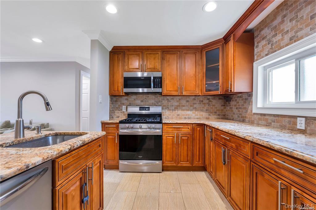 531 Old Country Road Plainview, NY 11803 - Photo 4 of 28 a kitchen with stainless steel appliances granite countertop a stove a sink and a microwave