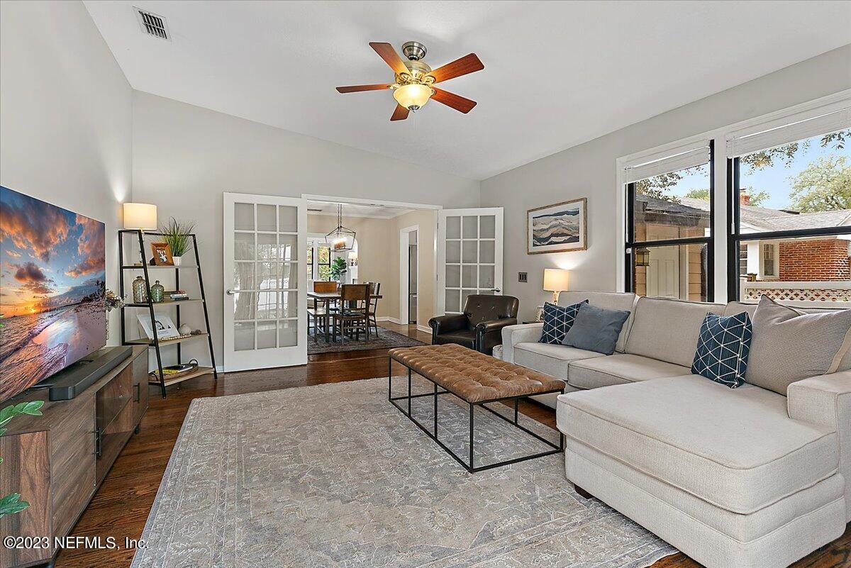 1445 Nicholson Road Jacksonville, FL 32207 - Photo 14 of 31 a living room with furniture a flat screen tv and floor to ceiling window