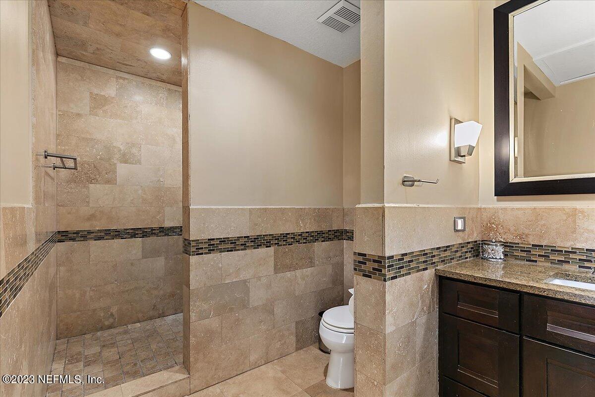 1445 Nicholson Road Jacksonville, FL 32207 - Photo 18 of 31 a bathroom with a granite countertop sink toilet and shower