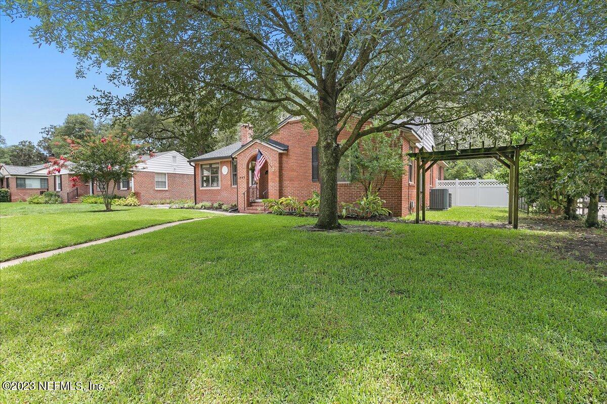 1445 Nicholson Road Jacksonville, FL 32207 - Photo 2 of 31 a front view of a house with a garden and trees