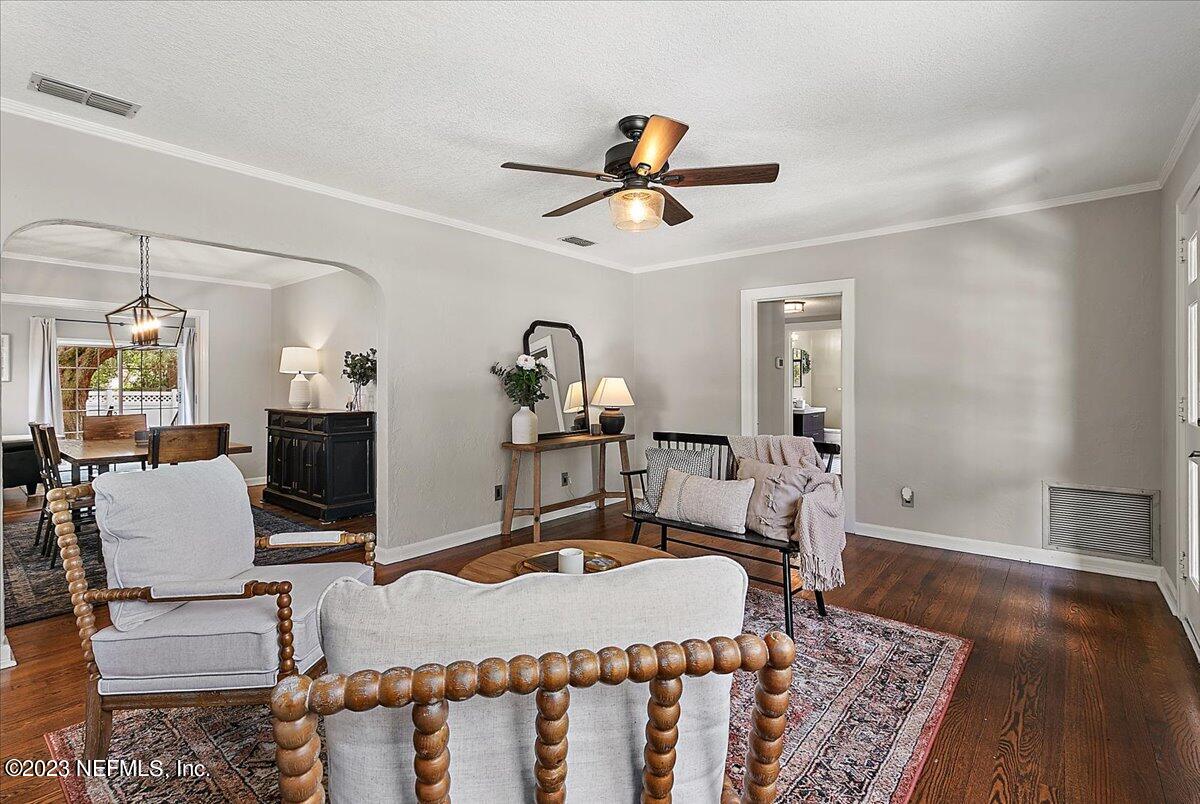 1445 Nicholson Road Jacksonville, FL 32207 - Photo 6 of 31 a dining room with wooden floor a chandelier fan a wooden table and chairs