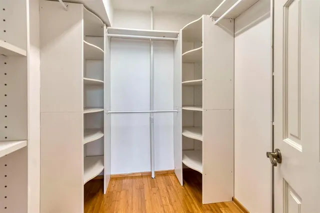 a view of walk in closet with empty racks